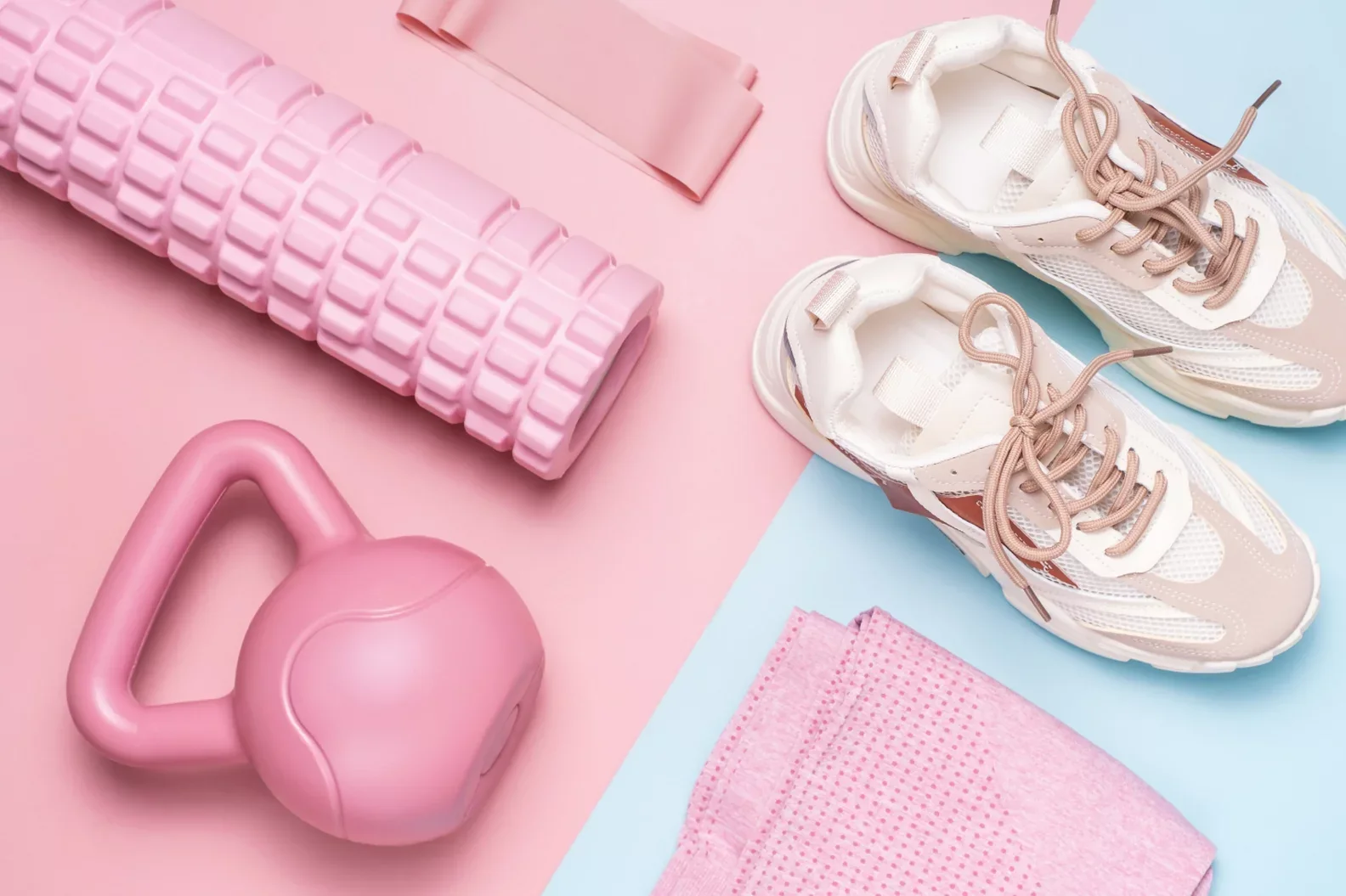 Colourful fitness equipment arranged on a pink and blue background